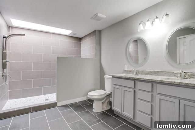 A second beautifully appointed bathroom, maintaining the theme of modern elegance with updated fixtures and ample storage.