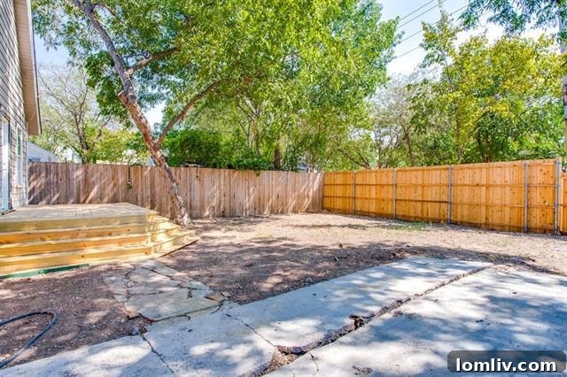 The newly renovated backyard, featuring a spacious deck with infinity stairs and a new privacy fence.