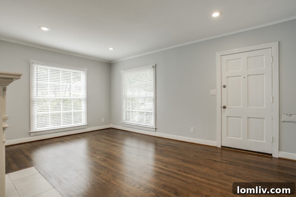 Interior view of the living room at 7014 Vivian Ave, showcasing refinished oak floors and a decorative fireplace.