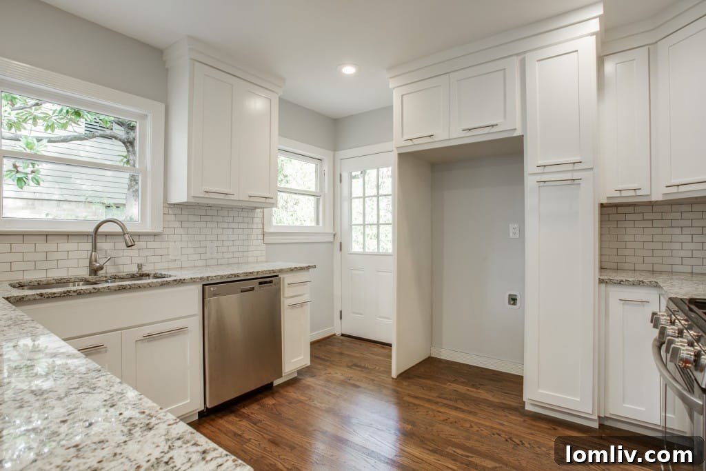 Open-concept kitchen with white custom cabinets, granite countertops, and stainless steel appliances.