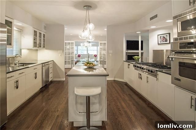 Spacious living area with custom lighting and hardwood floors