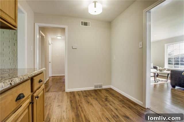 Modern galley kitchen featuring new cabinets, granite countertops, and stainless steel appliances.