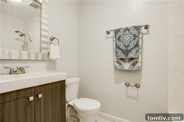 Hallway leading to the bedrooms, featuring consistent hardwood flooring and fresh paint.