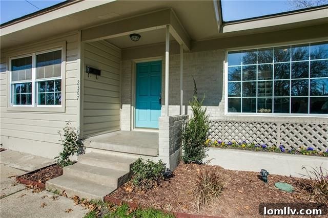 Rear exterior view of 2367 Highwood Drive, showcasing the backyard, newly painted facade, and part of the bonus room addition.