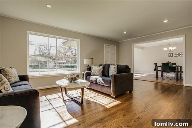 Bright living room of 2367 Highwood Drive with gleaming hardwood floors, a large picture window, and vintage built-in bookshelves.