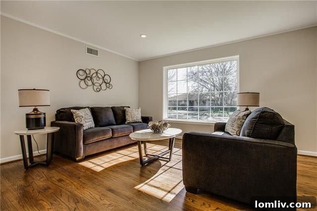 Another perspective of the renovated living room, highlighting the open layout and fresh paint, inviting natural light.