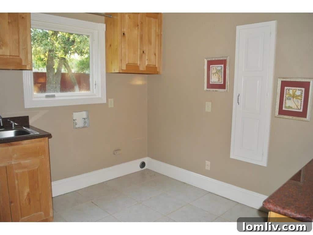Functional laundry room with ample storage cabinets and modern appliances.
