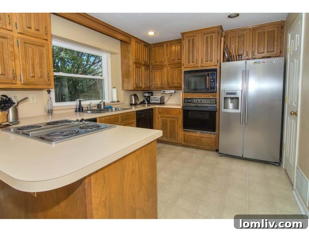 Outdated kitchen at 18605 Crownover Court, featuring Formica counters and older appliances.