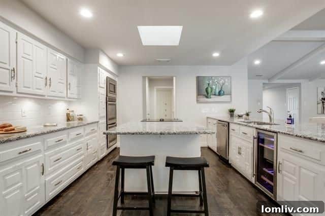Renovated kitchen with white cabinets, granite, and wine refrigerator