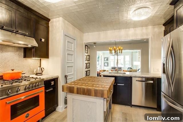 Modern kitchen with a vibrant orange oven and custom cabinetry in a Dallas home