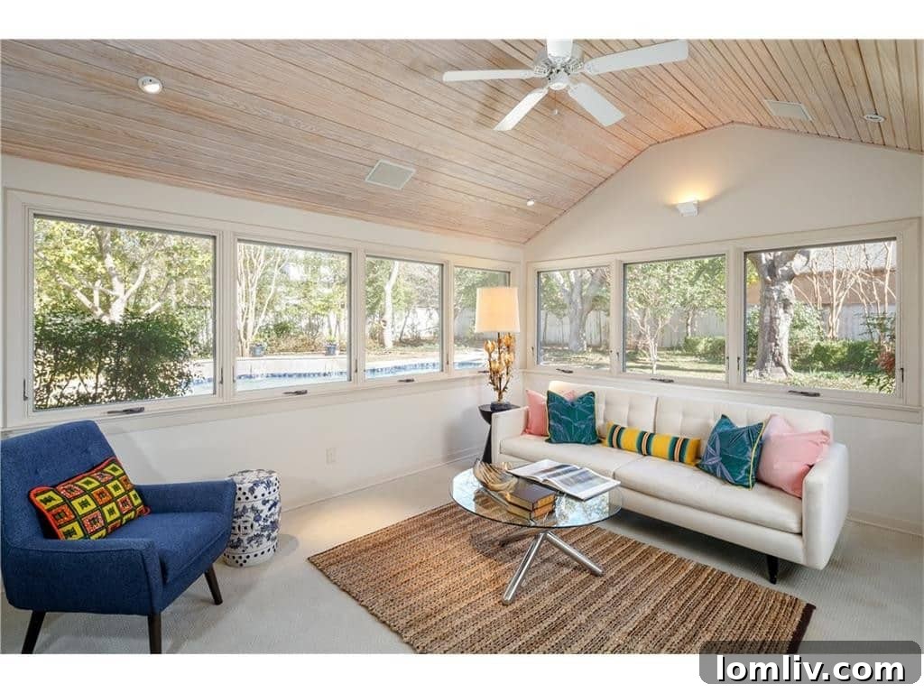 Second living area with vaulted ceiling, bleached hardwood, overlooking the pool, ideal for entertaining