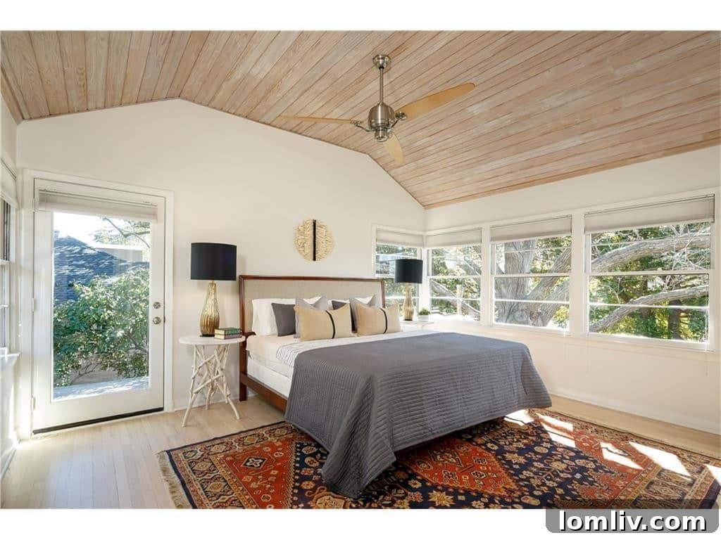 Master bedroom with vaulted ceiling and serene treetop views, offering a private sanctuary