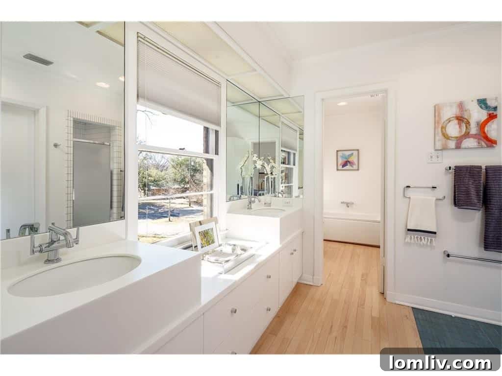 Spa-like master bathroom with dual sinks, modern fixtures, and streamlined storage