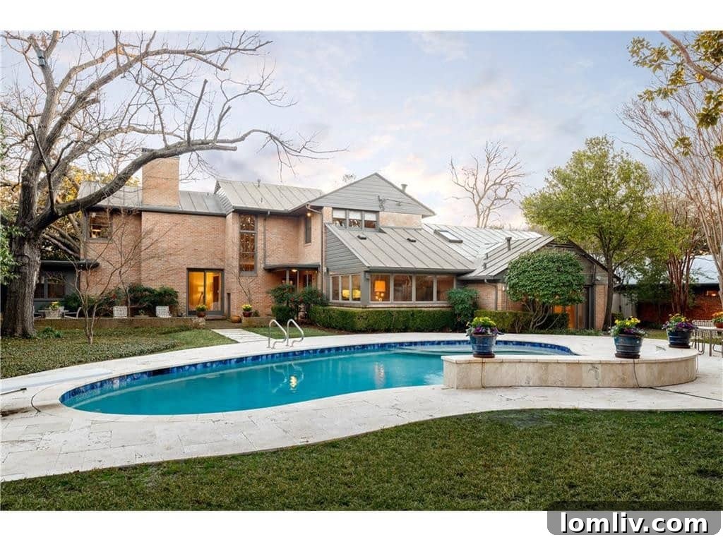 Spacious backyard with a lagoon-style pool, private garden, and brick patio, perfect for outdoor entertaining