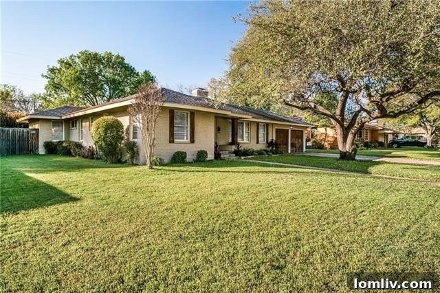 Beautifully updated exterior of 9715 Cloister Dr, featuring light tan brick, new wood shutters, and columns on the front porch, alongside lush landscaping.