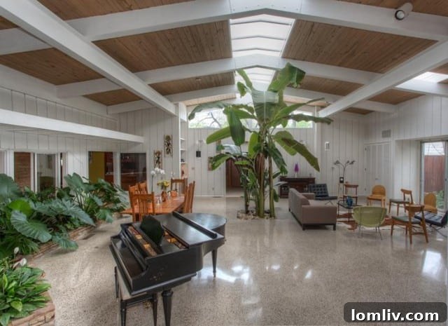 Grand entryway with terrazzo floors, planter, and high ceilings in 1950s style