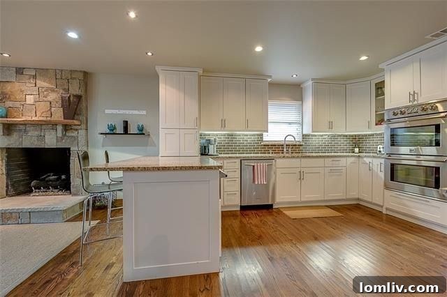 Gourmet kitchen with white cabinets, light granite, and modern appliances