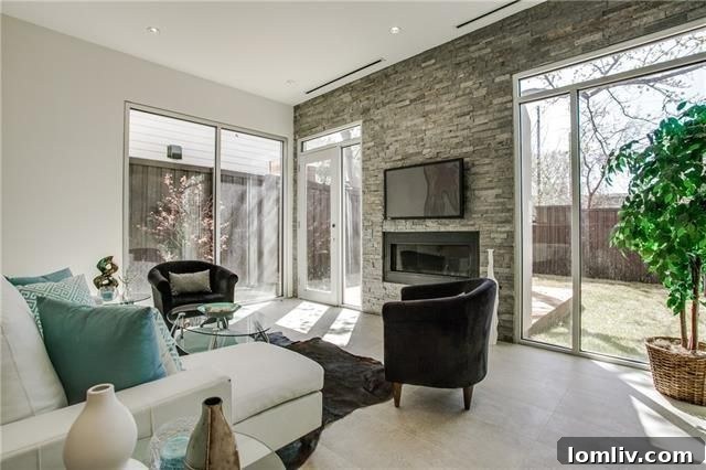 Spacious open concept living area with stone fireplace and large windows