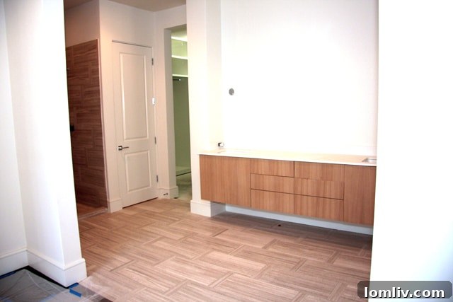 Master bath with warm limestone tile, floating double vanity, and ample storage in The Mondara