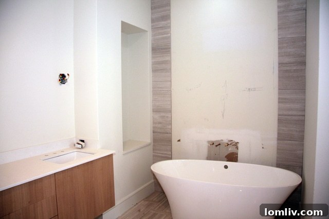 Freestanding tub and wood accent wall in master bath of The Mondara luxury condos