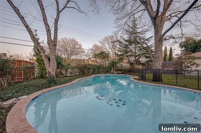 Lush backyard with a swimming pool and deck