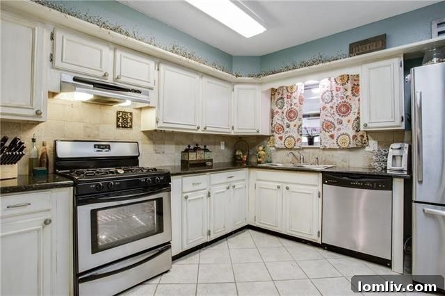 Modern white kitchen with stainless steel appliances and stone backsplash