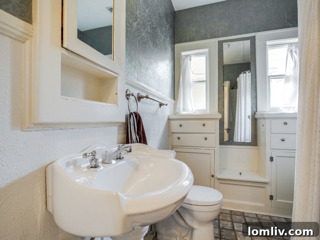 Iconic 1925 M Streets Prairie Craftsman: Timeless Charm, Ready for You 15 Charming hall bath featuring original cabinetry, period footed tub, and pedestal sink