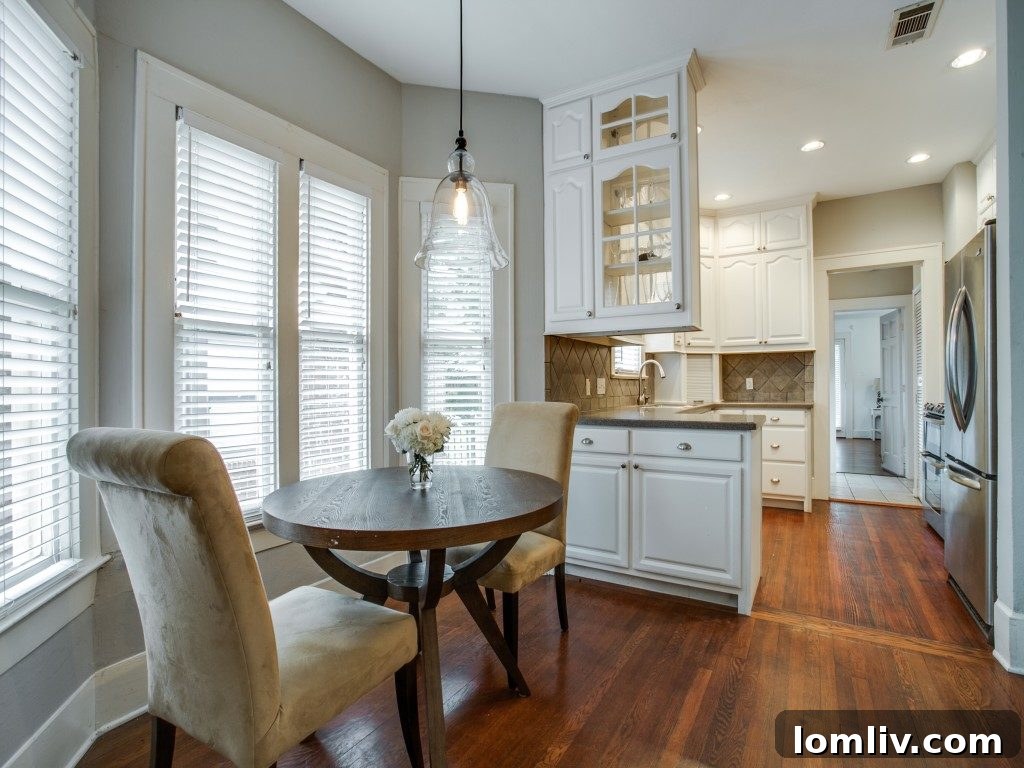 Iconic 1925 M Streets Prairie Craftsman: Timeless Charm, Ready for You 8 Updated kitchen with stainless steel appliances, Corian countertops, and glass-fronted cabinets