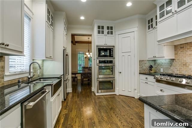 Modern kitchen with white cabinets, granite counters, and stainless steel appliances