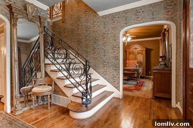 Elegant interior foyer with custom ironwork staircase at 3601 Ledgeview Court