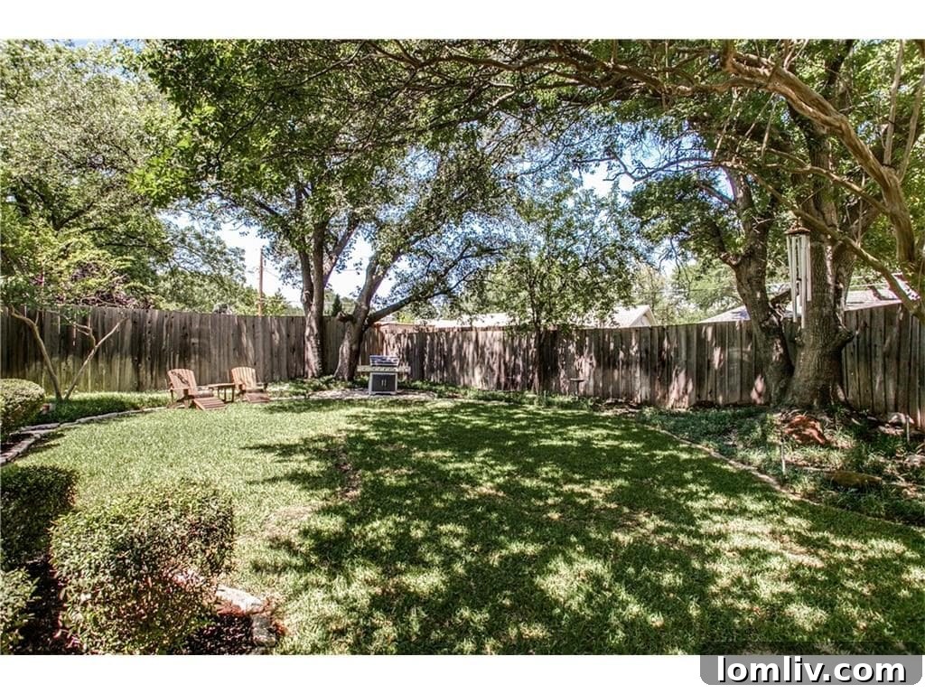 Rear yard view of 4939 Harvest Hill, emphasizing its privacy and lush landscaping.