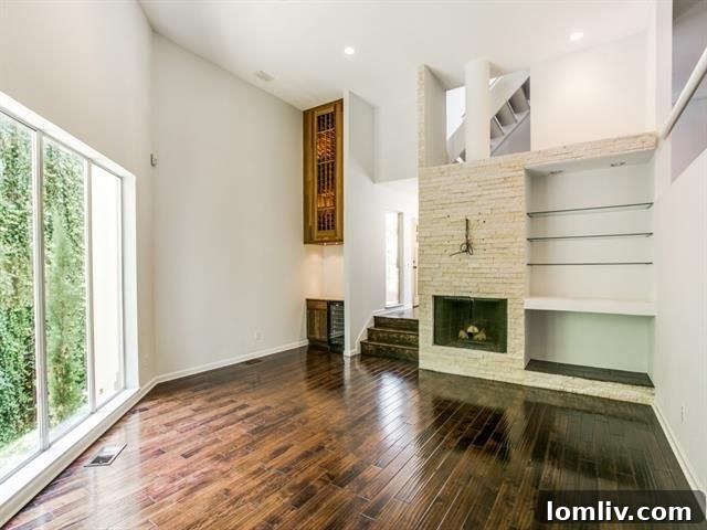 Spacious living room with 15-foot ceilings, Austin stone fireplace, and built-in wine refrigerator
