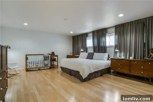 Bright secondary bedroom showcasing the consistent maple hardwood flooring found throughout the home