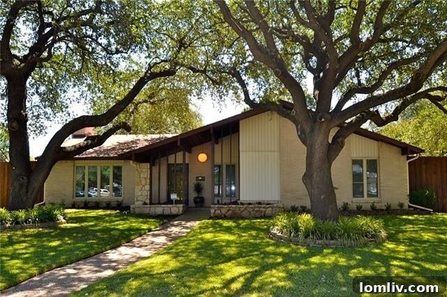 Lush front yard and vibrant curb appeal of the renovated mid-century home at 12634 High Meadow Drive