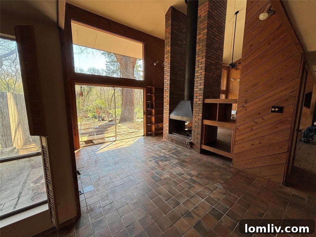 A view of the open-concept living space highlighting the multi-level layout, exposed wood beams, and a glimpse of the second-floor loft.