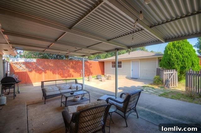 Backyard view with covered patio and mature trees