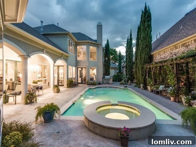 Serene pool and spa area with Italian cypresses in the backyard