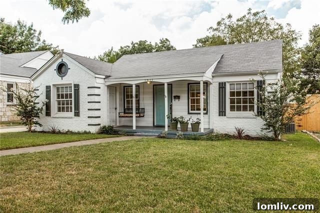 Bright and airy living room with original hardwood floors and a decorative fireplace in the Elmwood cottage