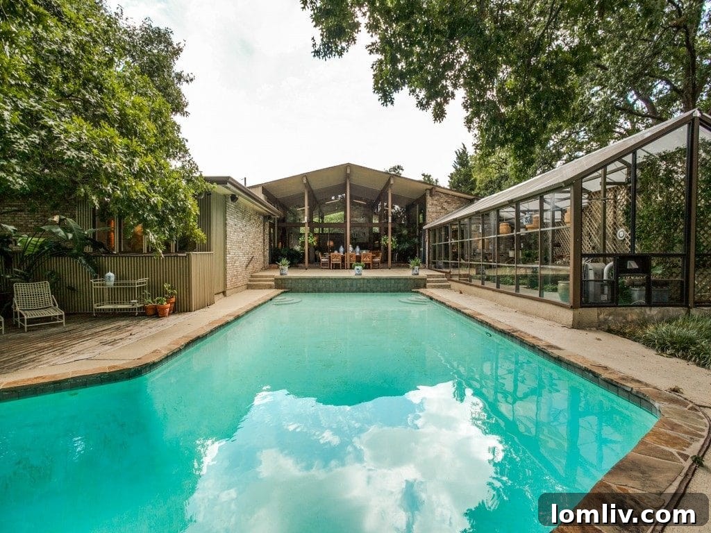 Aerial view of the stunning backyard, showcasing the large swimming pool and waterfront access.