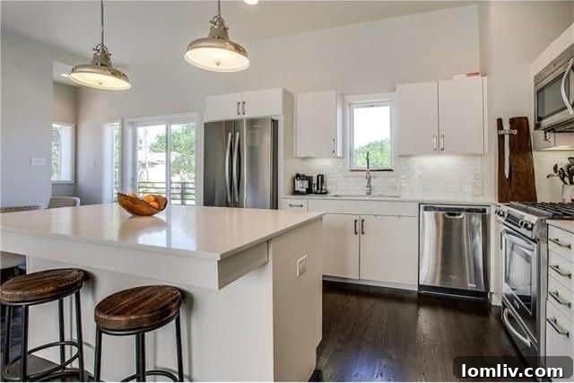 Contemporary kitchen featuring Caesarstone quartz counters, custom white cabinetry, and stainless steel appliances