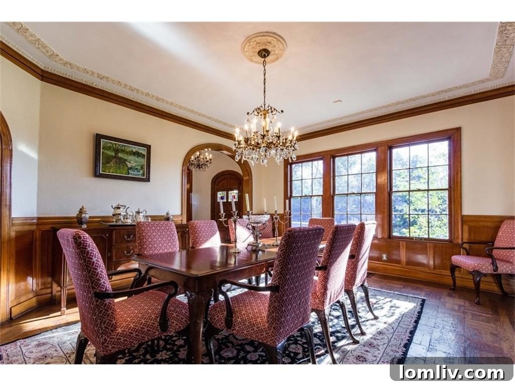 The grand formal staircase, featuring dark wood banisters and intricate detailing, a hallmark of the home's historic charm.