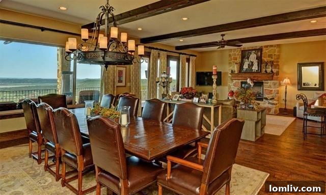 Luxurious Open-Concept Living and Dining Area with abundant natural light, lake views, and a prominent stone fireplace