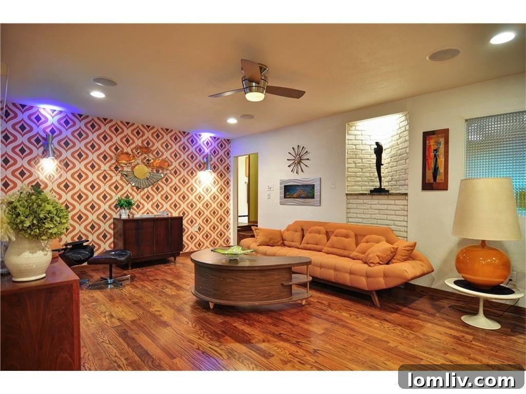 Vibrant 'Trippy Orange' wallpaper in a stylish family room, true to midcentury design