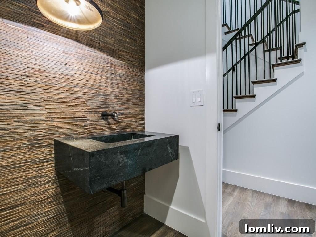 Lakewood Creekside Farmhouse: Modern Texas Living 13 Exquisite powder bathroom with a striking stacked stone accent wall and an elegant soapstone sink.