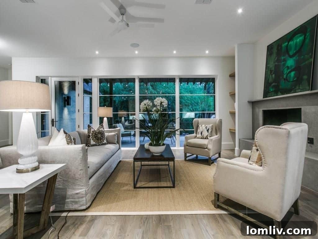 Lakewood Creekside Farmhouse: Modern Texas Living 7 Spacious open-plan living room with light gray stained white oak floors and large windows.