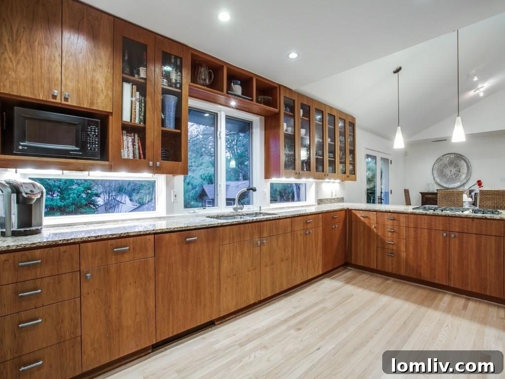 Frank Welch Protégé Redefines Texas Contemporary in Lake Park Estates 11 Close-up of the kitchen island and countertops, highlighting the rich texture of the tongue oil-finished cherry wood cabinets.