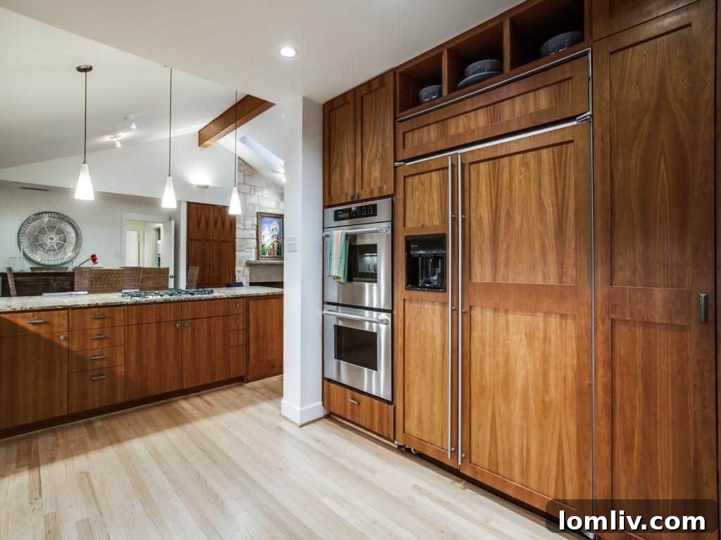 Frank Welch Protégé Redefines Texas Contemporary in Lake Park Estates 12 Panoramic view of the integrated kitchen and dining area, demonstrating the open and fluid layout ideal for entertaining.