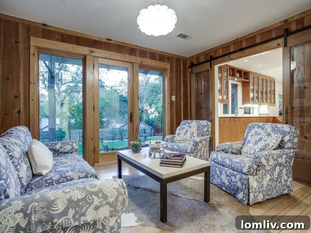 Frank Welch Protégé Redefines Texas Contemporary in Lake Park Estates 14 Charming den enclosed by stylish glass barn doors, offering a modern twist on a classic space, filled with natural light.