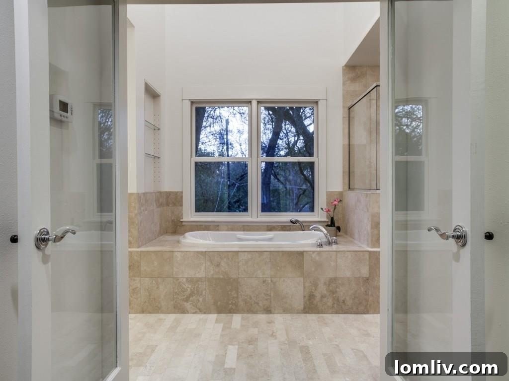 Frank Welch Protégé Redefines Texas Contemporary in Lake Park Estates 17 Luxurious bathroom featuring modern fixtures, a spacious shower, and elegant tile work.