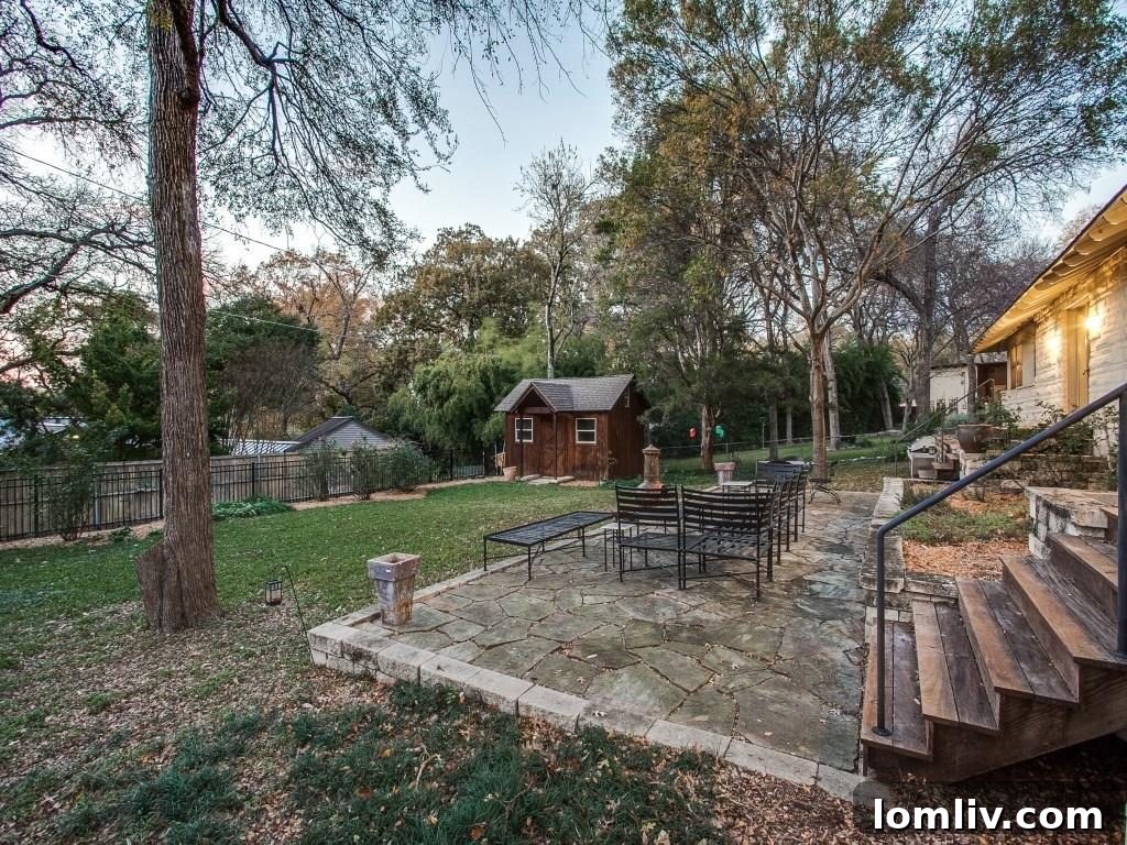 Frank Welch Protégé Redefines Texas Contemporary in Lake Park Estates 23 Expansive backyard with lush greenery, ample space for outdoor activities, and a detached workshop, hinting at the potential for a future swimming pool.